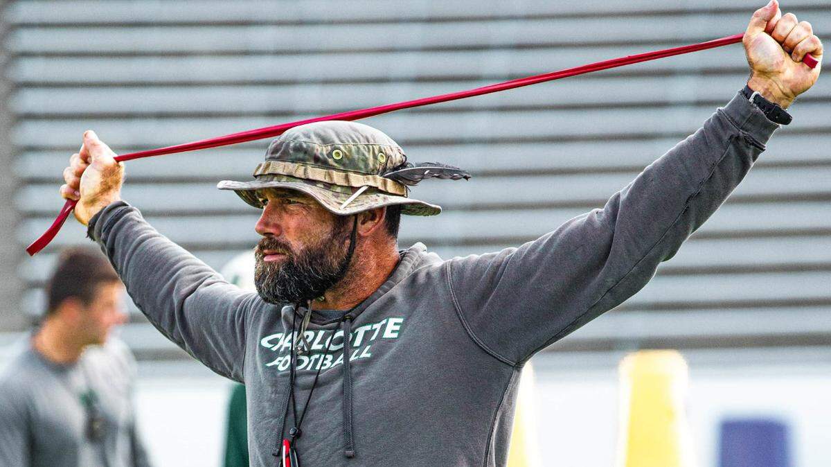 Charlotte 49ers director of football performance Chris Laskowski stretches during a preseason practice. Laskowski and the 49ers open their season Saturday, Aug, 27, at Florida Atlantic, Laskowski’s alma mater.