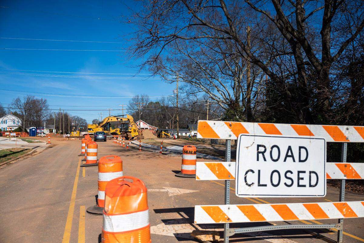 A sign indicating a road closing on Thrift Road while a new roundabout is currently under construction at the intersection of Tuckaseegee Road, Berryhill Road and Thrift Road on Wednesday, December 15, 2021 in Charlotte, NC. This project will replace the traffic signal at the existing five-leg intersection with a roundabout. There will also be improvements to the crosswalks, as well as new sidewalks, bicycle accommodations, planting strips and landscaping.