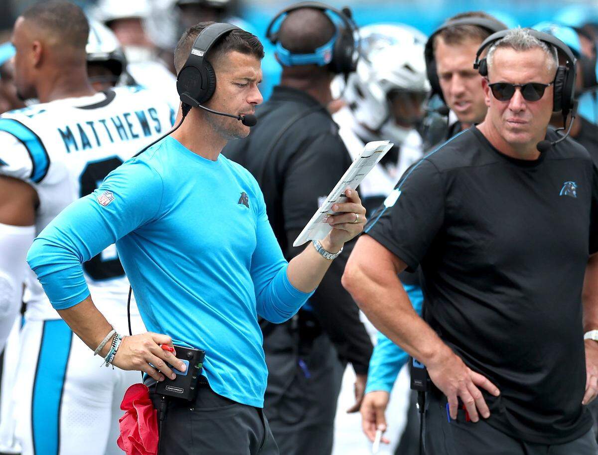 Carolina Panthers head coach Dave Canales, center, looks over his play sheet during action against the Los Angeles Chargers on Sunday, September 15, 2024 at Bank of America Stadium in Charlotte, NC. The Chargers defeated the Panthers 26-3.