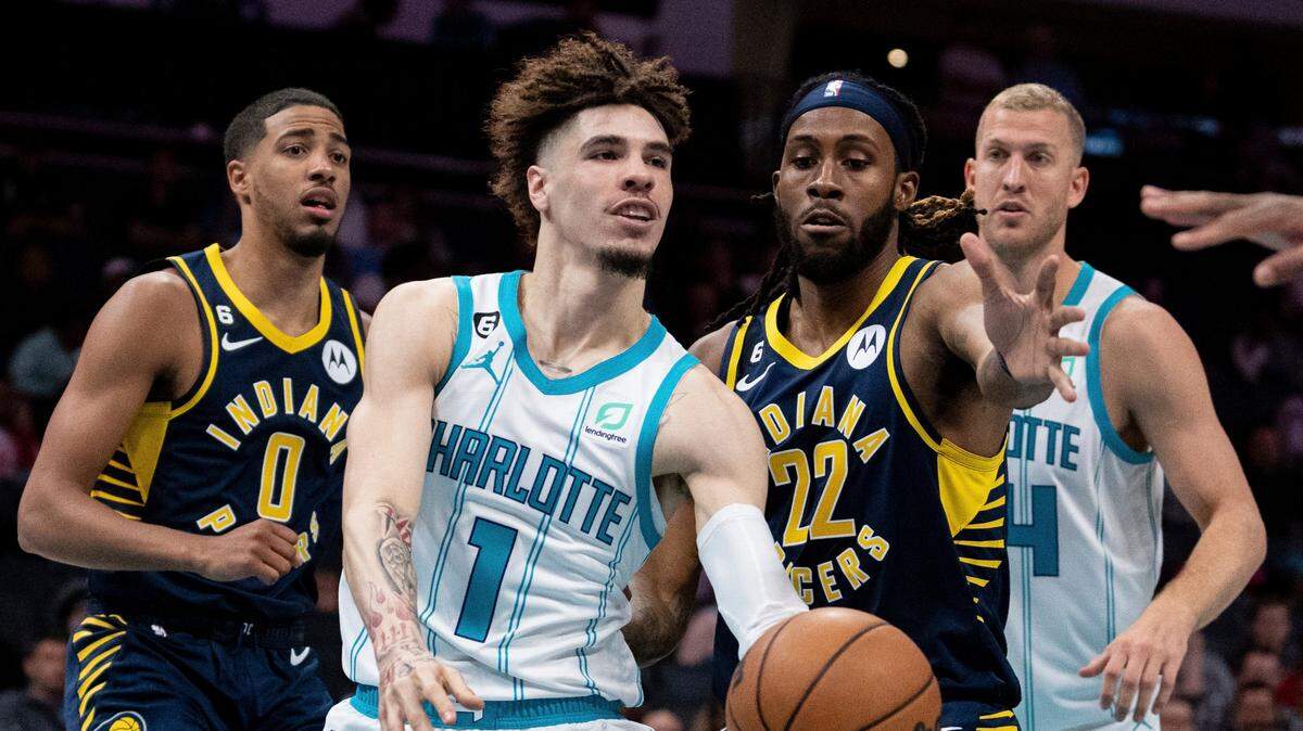 Charlotte Hornets guard LaMelo Ball (1) passes the ball while guarded by Indiana Pacers forward Isaiah Jackson (22) during the first half of an NBA preseason basketball game in Charlotte, N.C., Wednesday, Oct. 5, 2022. (AP Photo/Jacob Kupferman)
