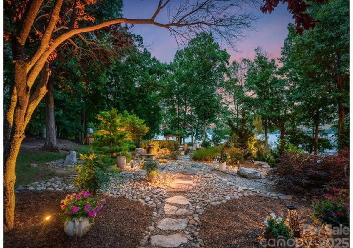 The Lake Norman home for sale includes an elevated “memory garden” whose stone pathway leads to a fire pit where the owners watch the sun rise and set.