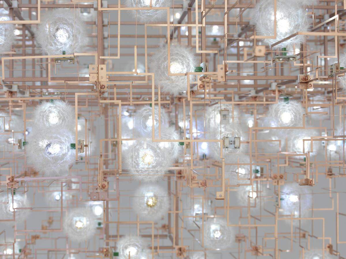 This is an up-close look at part of Studio Drift’s “Fragile Future” installation. The light sculpture consists of bronze electrical circuits connected to light emitting dandelions. Yes, those are real dandelion seeds, picked by hand and glued to LED lights.