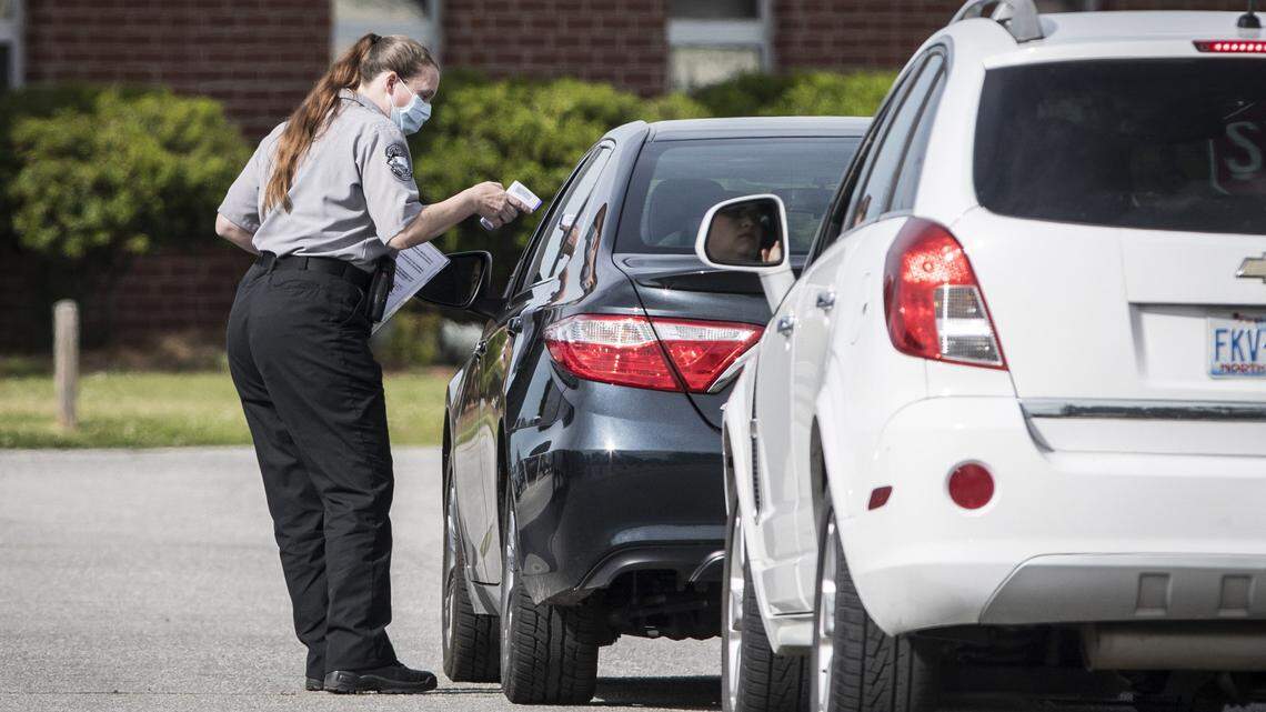 An employee at Pender Correctional Institution takes someone’s temperature before allowing them to enter the prison’s parking lot. One of the prison’s inmates died after contracting COVID-19.