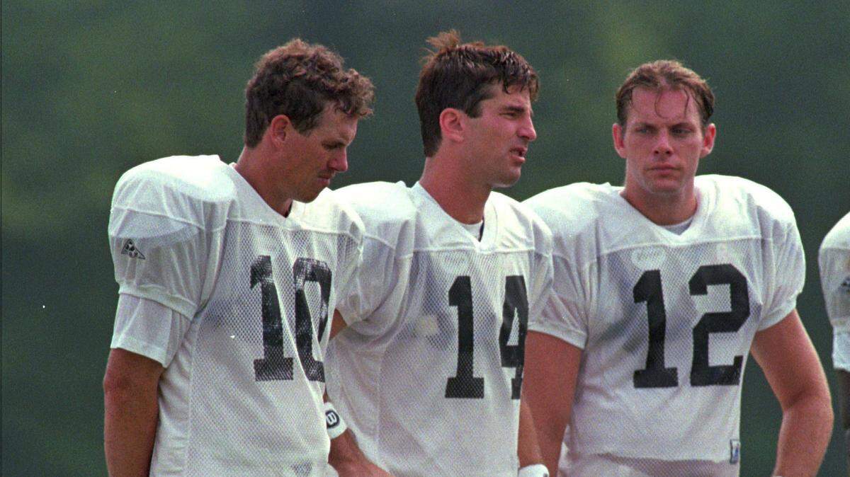 Panthers quarterbacks (left to right) Jack Trudeau, Frank Reich and Kerry Collins huddle at practice Friday, July 21, 1995. Reich (14) started the Panthers’ first three games of the regular season but was replaced by Collins for the final 13. More than 27 years later, in January 2023, Reich would be named the Panthers’ head coach.