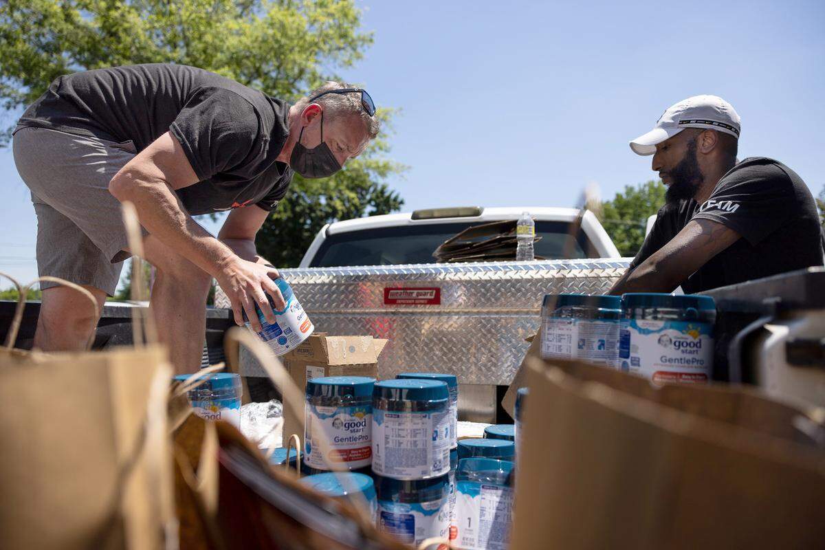 Adam Hummel, left, and Glenn Vernon unload a truck of baby formula to be given out at StarMed Healthcare in Charlotte, N.C., on Tuesday, May 17, 2022.