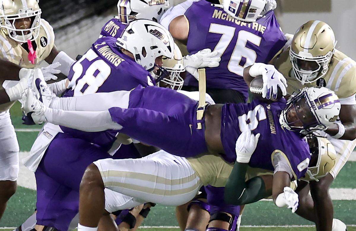 Charlotte 49ers linebacker Stone Handy throws James Madison University running back George Pettaway to the turf in the backfield during action on Saturday, August 31, 2024 at Jerry Richardson Stadium.