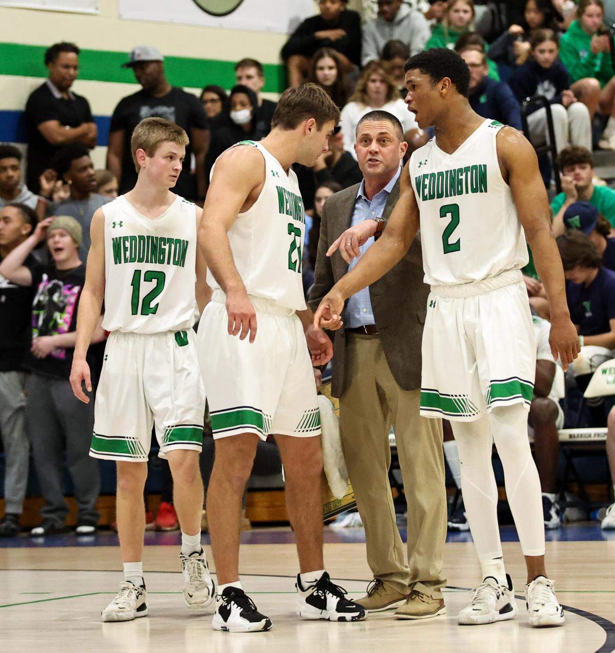 Weddington High’s Head Coach Gary Ellington, second from right, gives last minute advice to Weddington players AJ Cook, far left, Jack Werdann, second from left, and Chase Lowe, far right Tuesday Night against Chambers High.