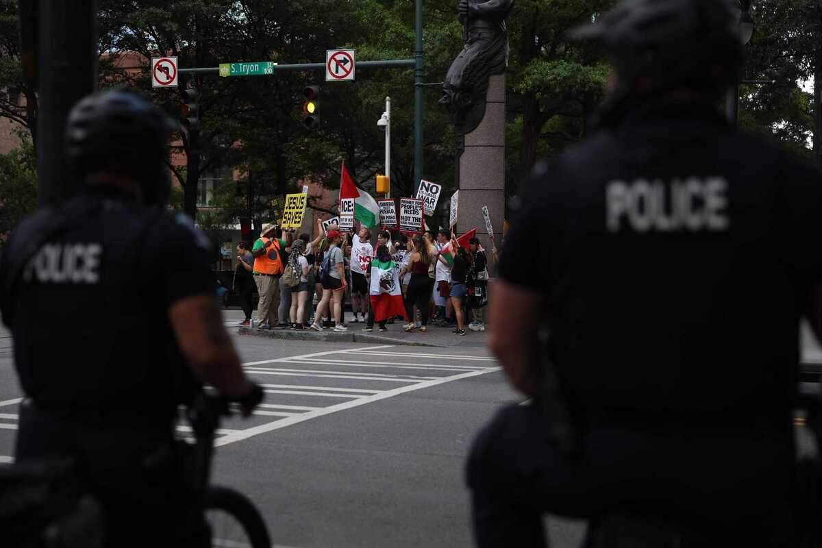 Police watch as protesters march for ‘No War on Iran!’ at Romare Bearden Park in Charlotte on Thursday.
