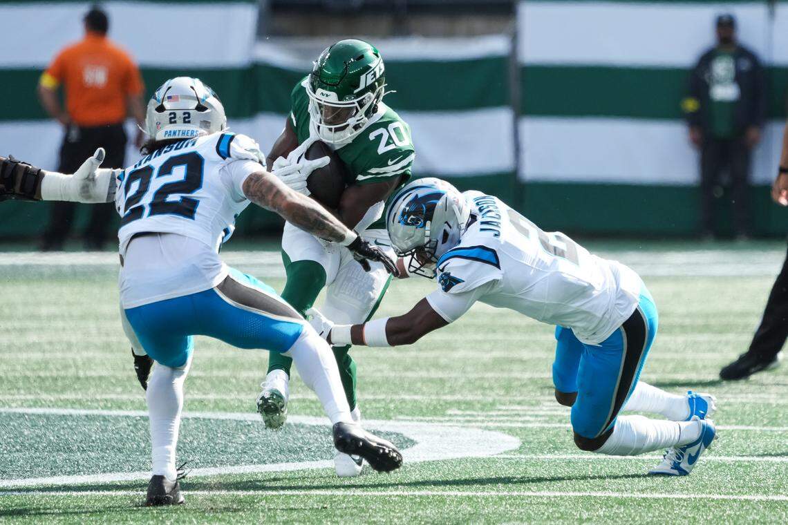 New York Jets running back Breece Hall (20) is tackled by Carolina Panthers cornerback Mike Jackson (2) in the first quarter on Sunday in New Jersey.