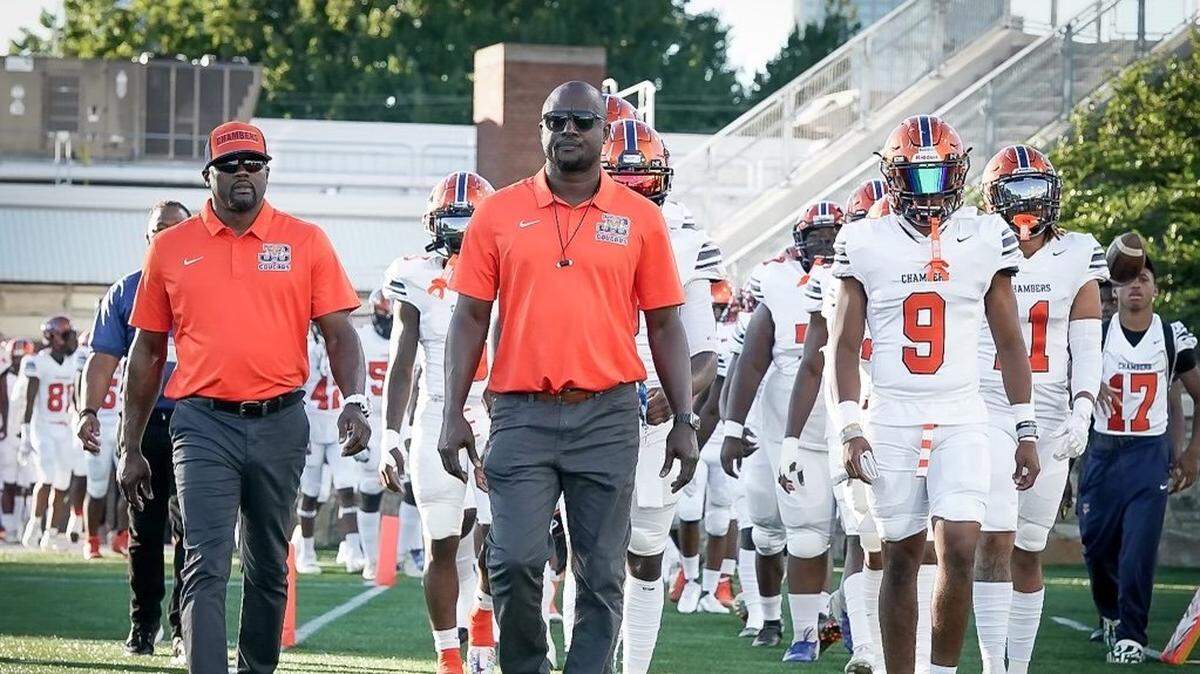 Chambers head coach Glenwood Ferebee leads his team out for Friday’s game against Hough at Memorial Stadium