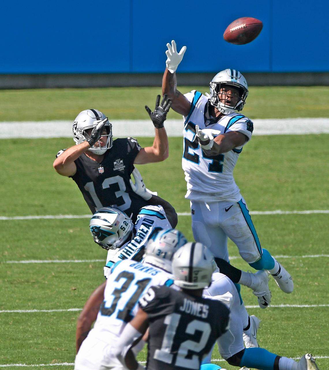 Carolina Panthers outside linebacker Tahir Whitehead (52) commits pass interference against Las Vegas Raiders wide receiver Hunter Renfrow (13) as cornerback Rasul Douglas (24) tries to intercept the ball during the fourth quarter in their opening game of the 2020 NFL season at Bank of America Stadium on Sunday, September 13, 2020. Las Vegas Raiders won. 34-30.