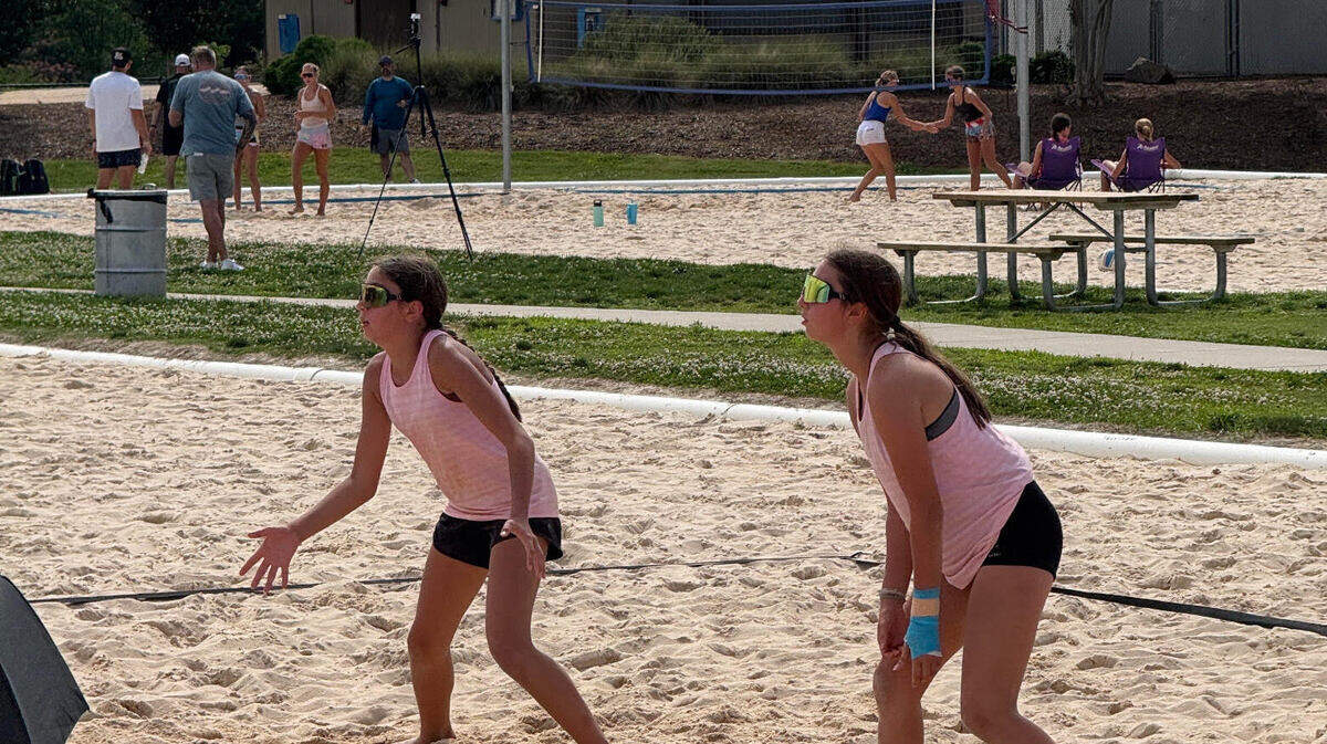 Carmen Markel and Harper Willis are focused while playing an outdoor volleyball game.