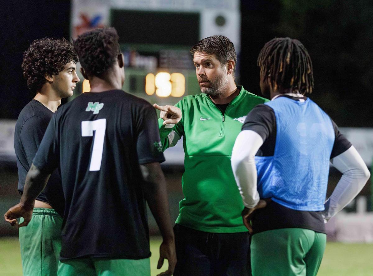 Mustang’s head coach Bucky McCarley (center) gives pre-game instructions to his defensive line up. Myers Park would host West Cabarrus in the 1st round of the NCHSAA high school soccer playoffs Saturday November 9, 2024.