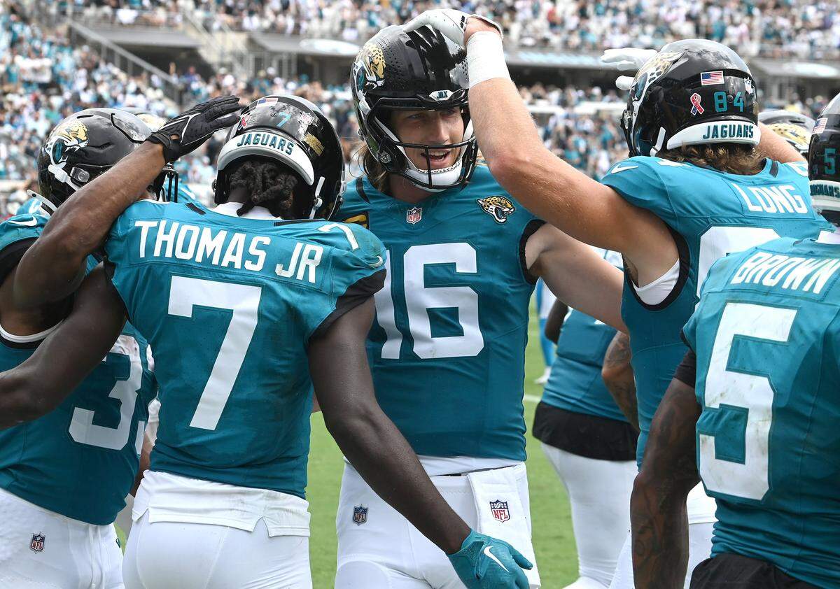Jacksonville Jaguars quarterback Trevor Lawrence, center, celebrates a touchdown by wide receiver Brian Thomas Jr., left, with his teammates during action against the Carolina Panthers on Sunday, September 7, 2025 at Everbank Stadium in Jacksonville, Florida. The Jaguars defeated the Panthers 26-10.