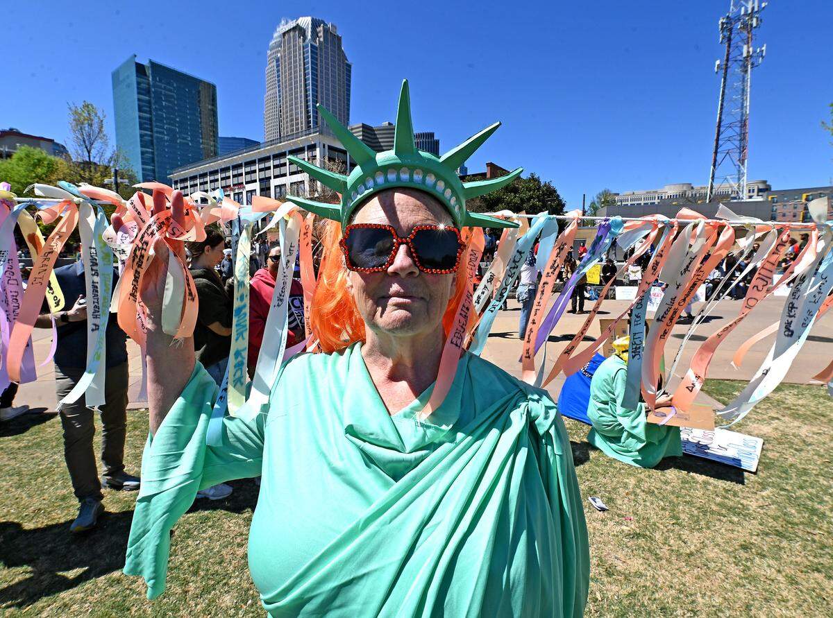 The Lady Liberty stands in front of a strand of message covered ribbons in First Ward Park during a No Kings rally in Charlotte, NC on Saturday, March 28, 2026.