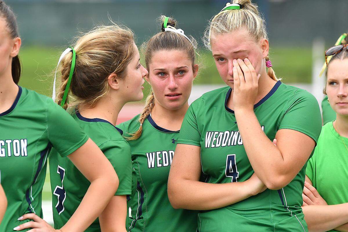 Weddington’s Logan Hailey (4) is consoled by Grace Webb (3) after their team’s loss to Cardinal Gibbons in the NCHSAA 4A Girls Lacrosse Championship Game. The Weddington Warriors and the Cardinal Gibbons Crusaders met in the Girls NCHSAA 4A Lacrosse Championship Game in Durham, N.C. on May 31, 2025.