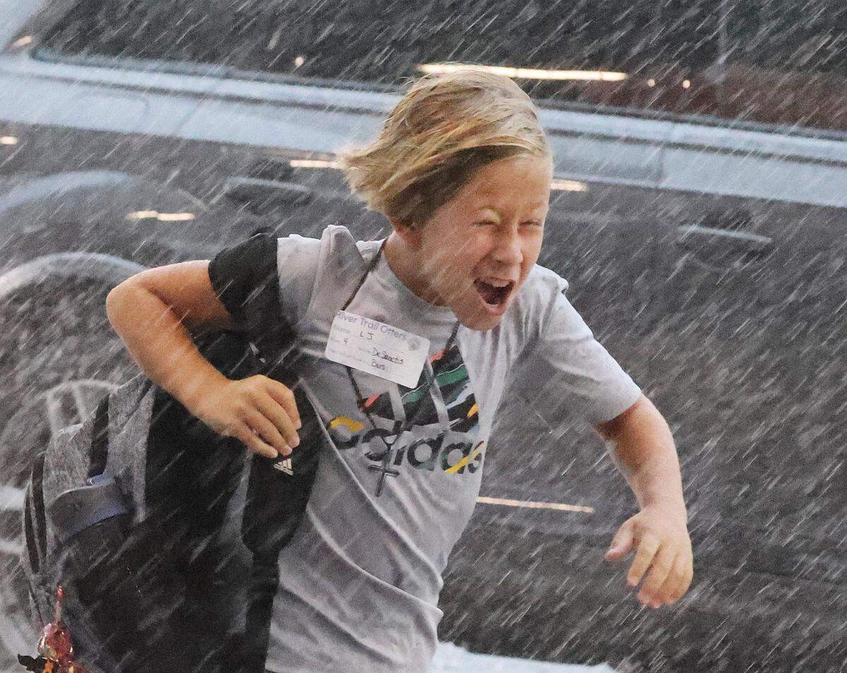 A boy runs through the rain Thursday at River Trail Elementary school. Thursday was the first day of school for the Fort Mill and Rock Hill school districts despite Debby dumping inches of rain into the area.