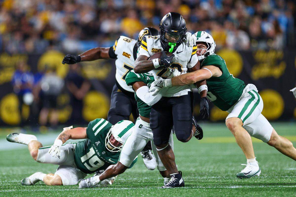 Gavin Willis, right, of the Charlotte 49ers attempts to tackle Jaquari Lewis of Appalachian State during the second half of the Duke's Mayo Classic at Bank of America Stadium on Aug. 29, 2025 in Charlotte, North Carolina.