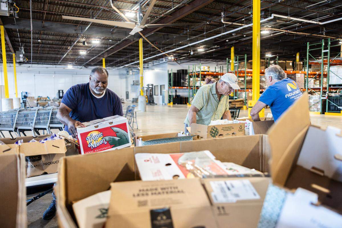 Volunteers pack bags of groceries at the new Nourish Up warehouse in Charlotte, N.C., on Tuesday, June 11, 2024. The Tepper Foundation will be donating $3 million to Nourish Up.