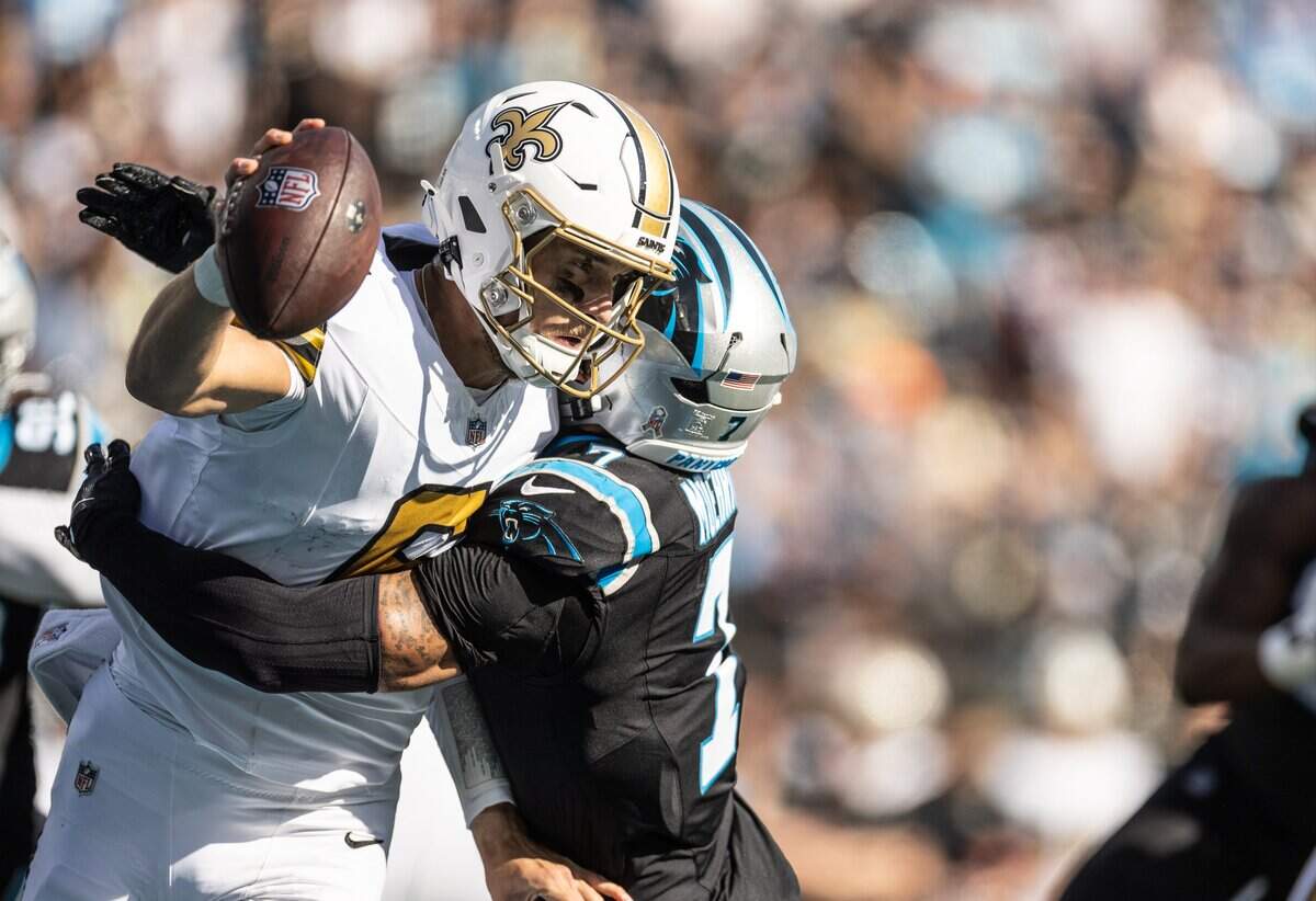 New Orleans Saints quarterback Tyler Shough, left, is sacked by Carolina Panthers safety Tre'von Moehrig at Bank of America Stadium in Charlotte on Sunday, November 9, 2025.