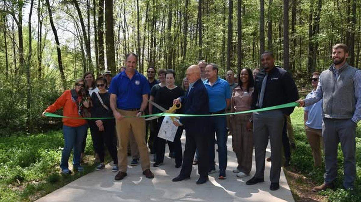 Cornelius Mayor Woody Washam cuts the ceremonial ribbon on Caldwell Station Tributary Greenway.