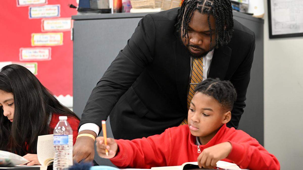Kenneth Gorham, center, works with student Jayden Anderson, right, during a sixth grade class on Tuesday, January 10, 2023. Gorham is the principal of Movement Freedom Middle School in Charlotte, NC. 