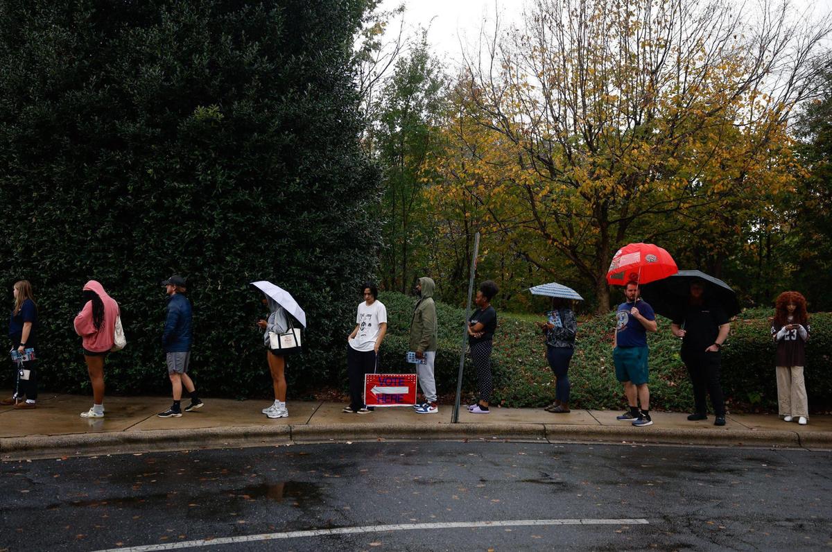 Several people stand in a long line to vote at Charlotte Mecklenburg Library in University City on election day in Charlotte, NC on Tuesday, November 5, 2024.