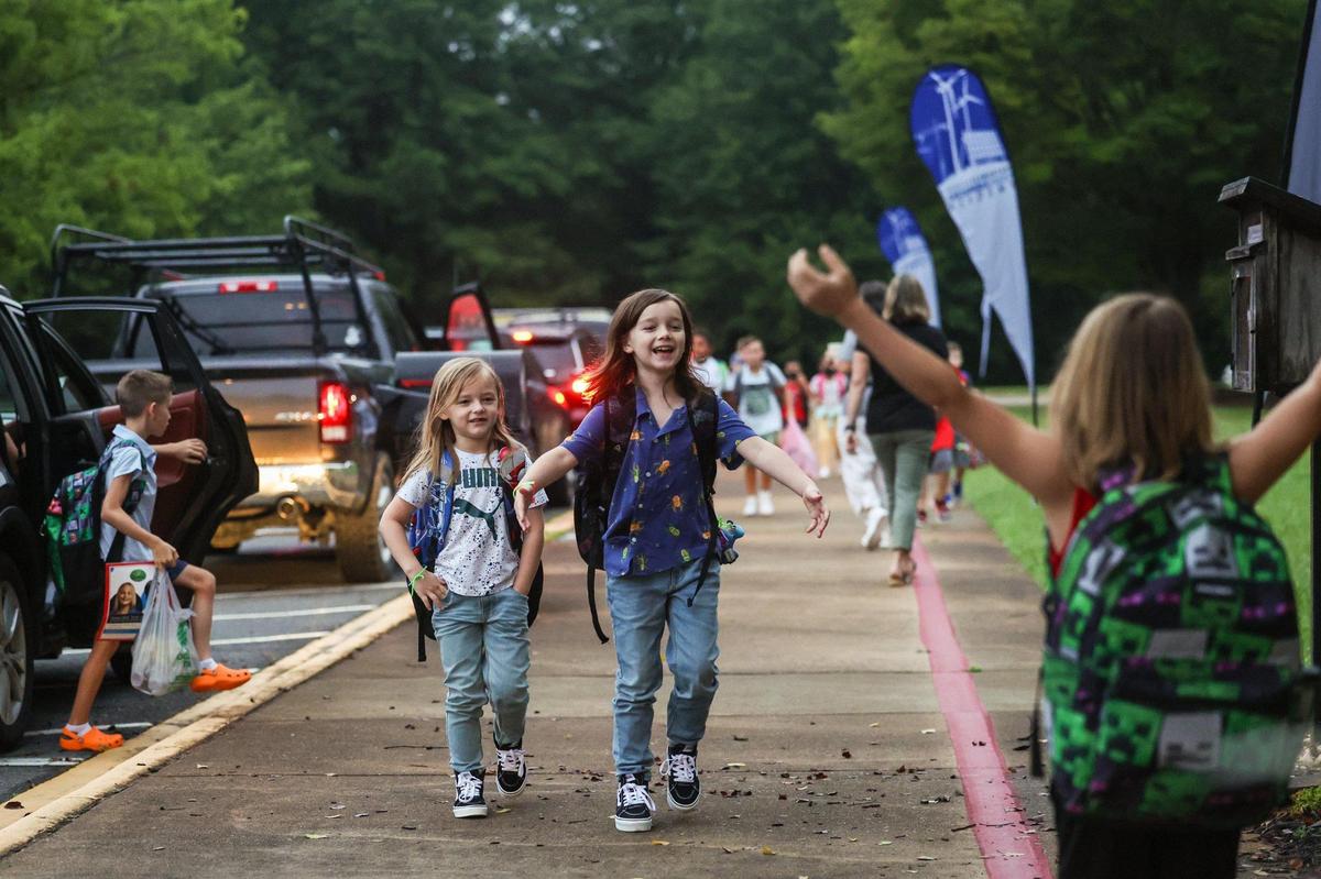 Friends excitedly greet each other as they arrive for the first day of school at Waxhaw Elementary School on Monday, August 28, 2023.