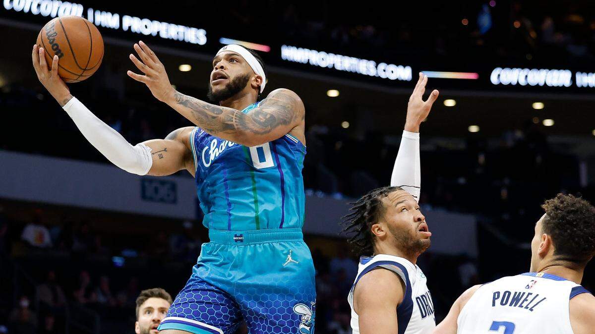 Charlotte Hornets forward Miles Bridges (0) shoots over Dallas Mavericks forward Maxi Kleber (42) Dallas Mavericks guard Jalen Brunson (13) and Dallas Mavericks center Dwight Powell (7) during a game at Spectrum Center in Charlotte, N.C., Saturday, March 19, 2022.