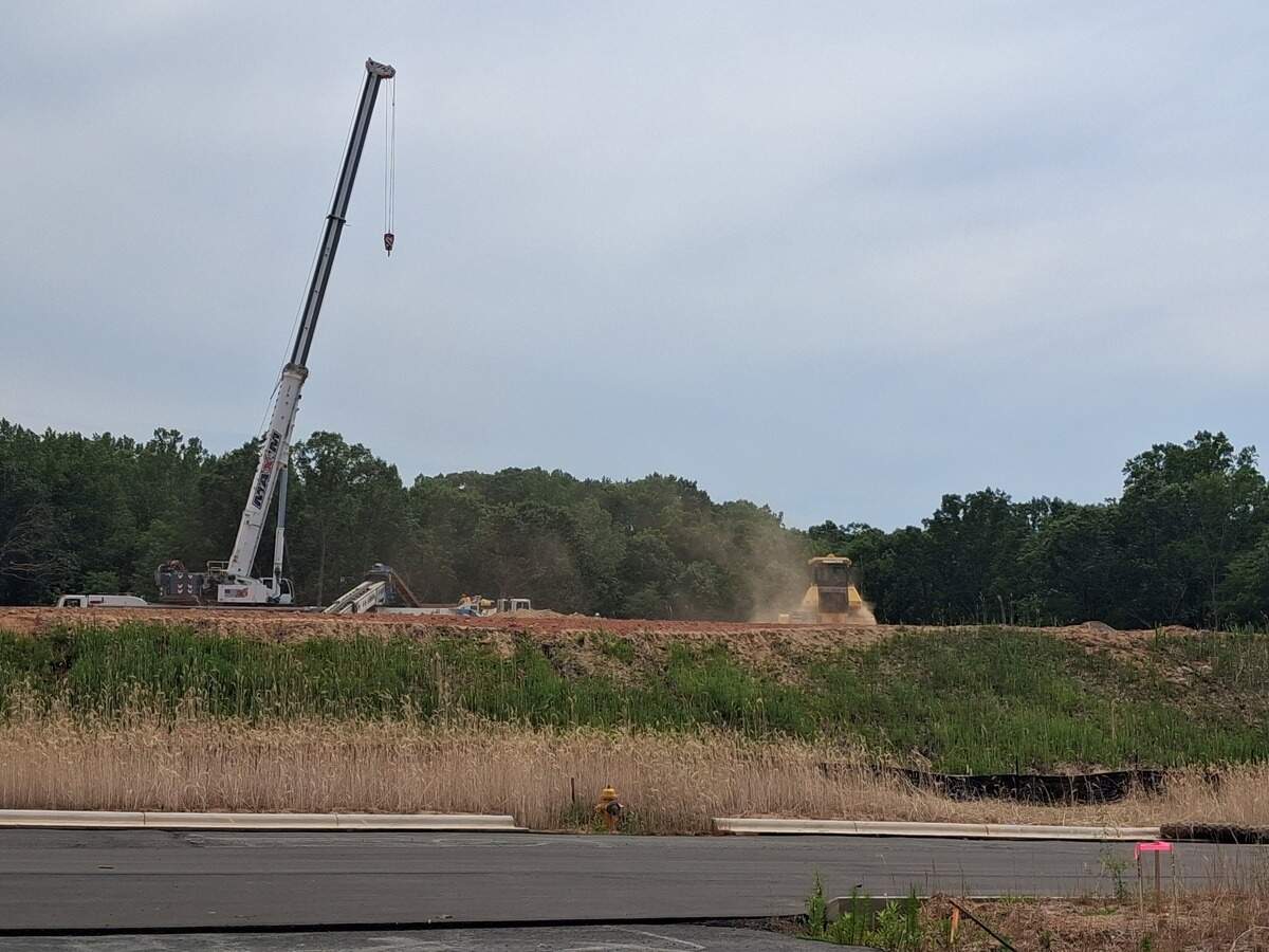 Crews grade land along the planned East West Connector for a Lowes Foods grocery store on Tuesday, June 16.