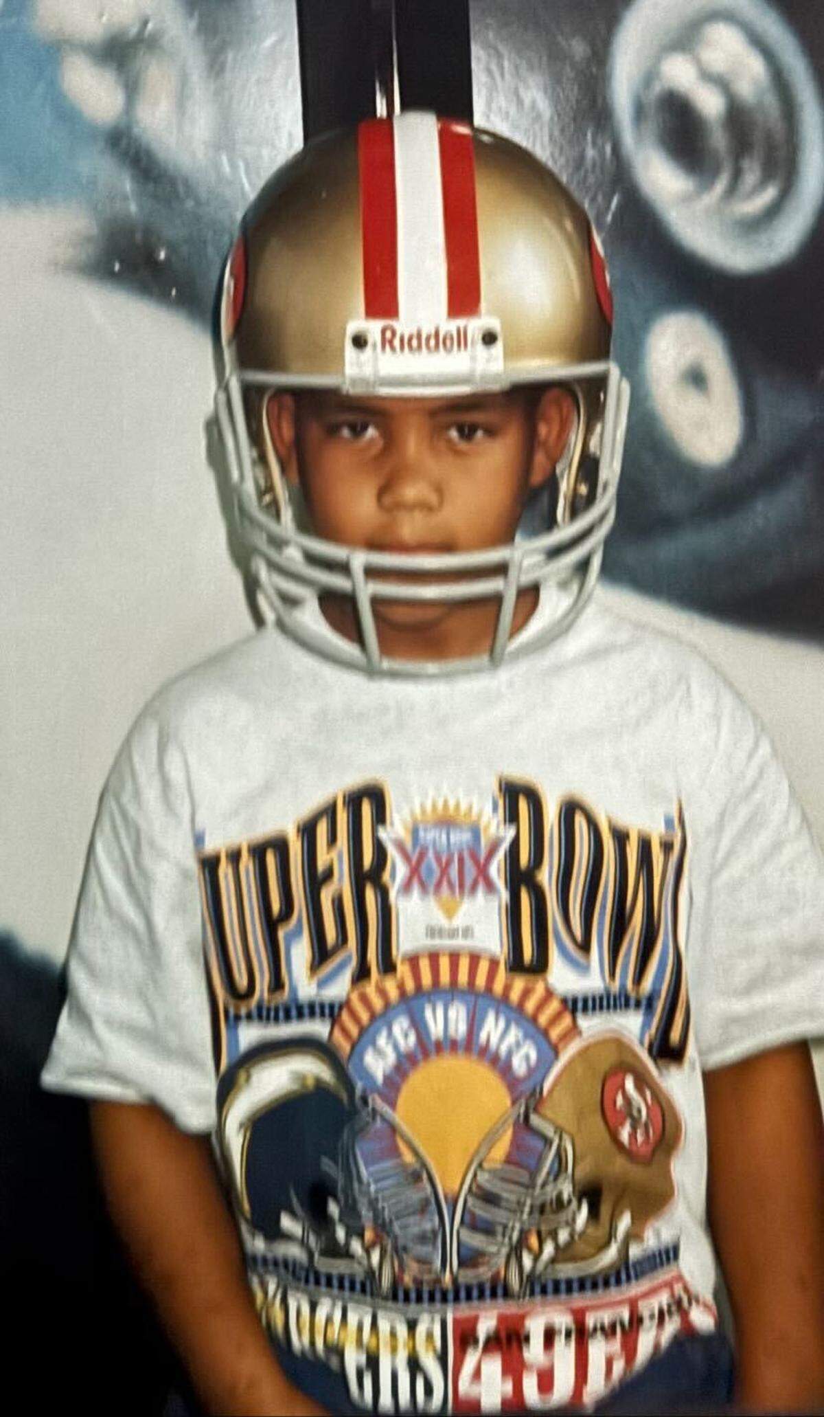 Carolina Panthers director of college scouting Jared Kirksey, pictured here as a child, wears a San Francisco 49ers helmet. Kirksey’s father, Larry, served as the 49ers’ wide receivers coach from 1994 to 1999. The elder Kirksey coached Jerry Rice and Terrell Owens during that tenure, and he won Super Bowl XXIX as a member of the staff.