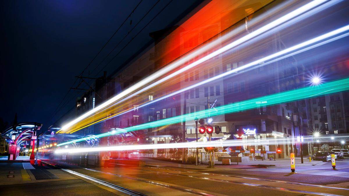 A light rail train passes over the crossing along New Bern Street near high end apartments and shops in Charlotte, on Feb. 26, 2022.