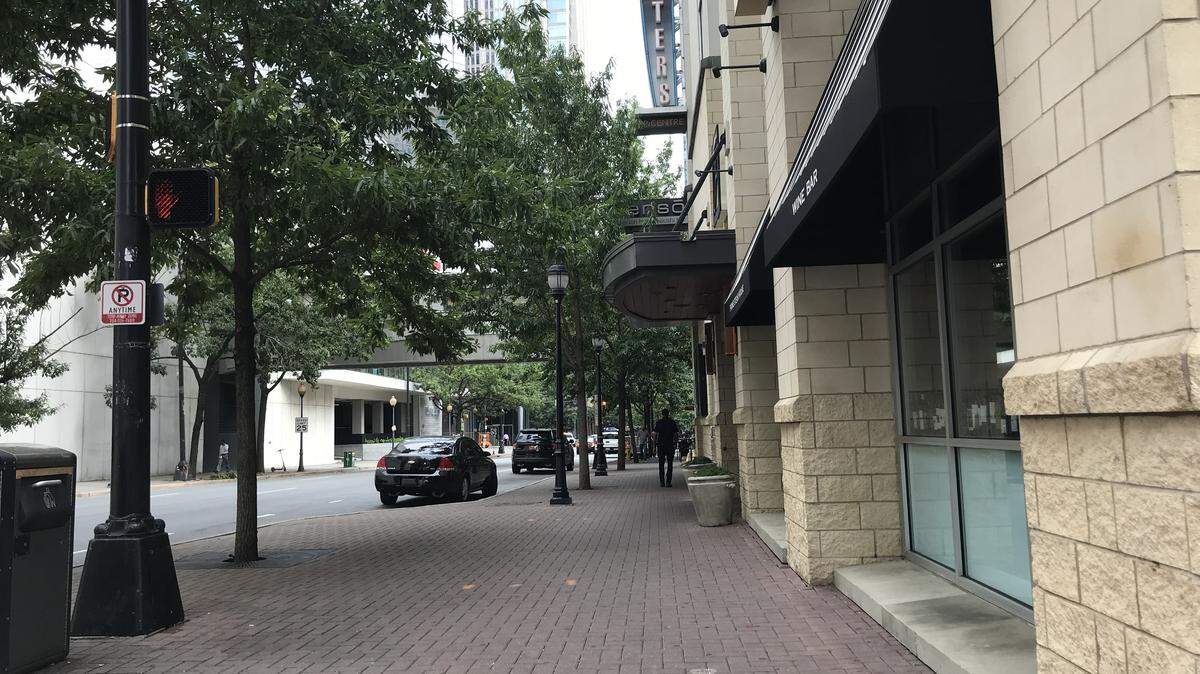 The sidewalk outside the Aloft hotel on South College Street in uptown Charlotte was peaceful late Tuesday morning, hours after an armed robbery ended with gunfire, police say.