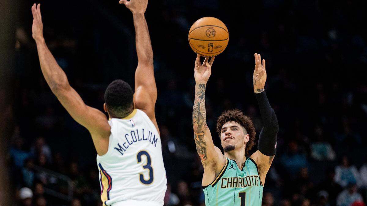 Jan 25, 2025; Charlotte, North Carolina, USA; Charlotte Hornets guard LaMelo Ball (1) shoots the ball against New Orleans Pelicans guard CJ McCollum (3) during the first quarter of at Spectrum Center. Mandatory Credit: Scott Kinser-Imagn Images