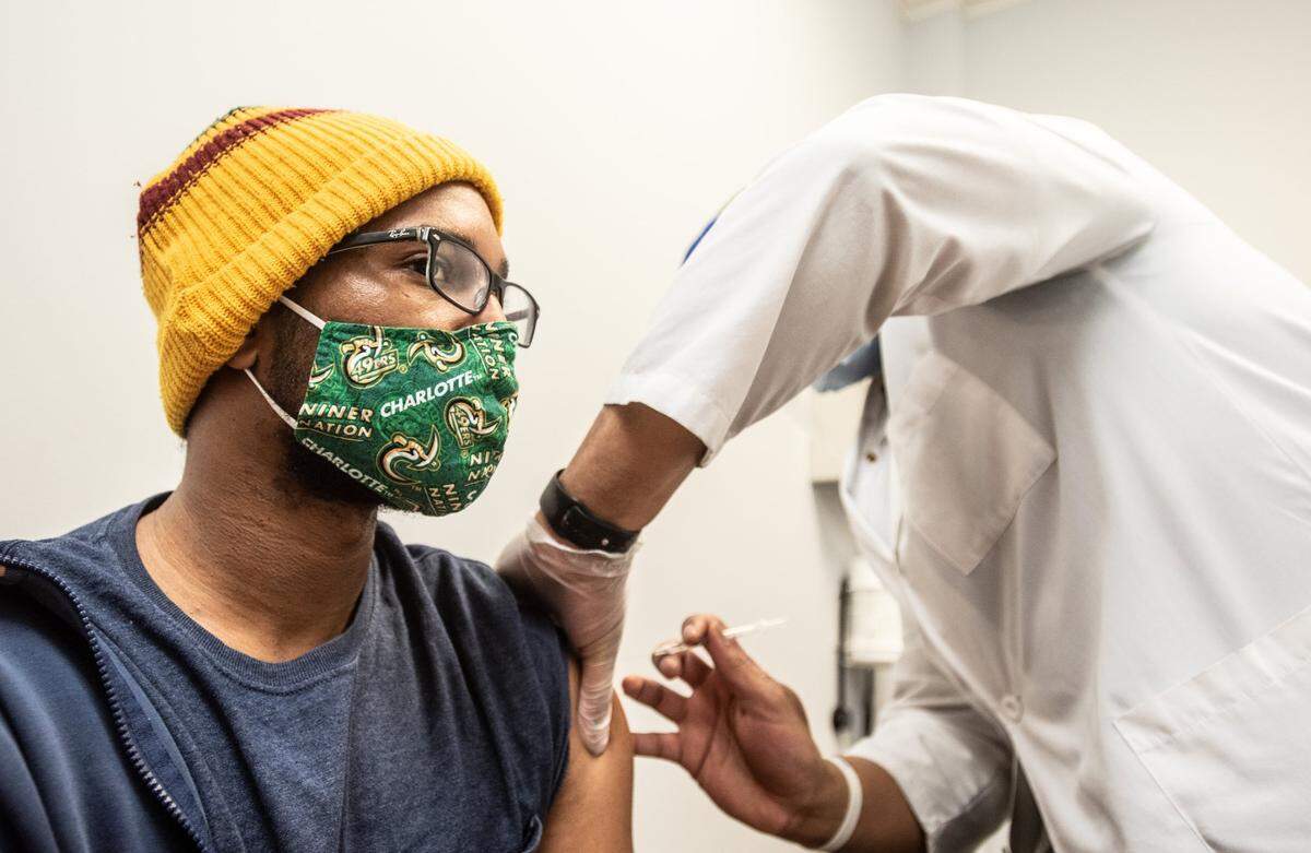 Tremaine Tillman (left) is administered the COVID-19 vaccine by Dr. Martez Prince at Premier Pharmacy And Wellness Center in Charlotte, NC, on Thursday, March 18, 2021.