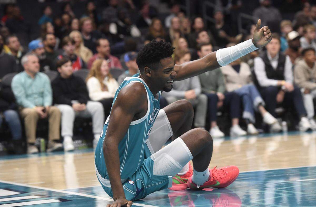 Charlotte Hornets forward Brandon Miller (24) signals for someone to help him up after a fall during the second half against the Philadelphia 76ers at the Spectrum Center.