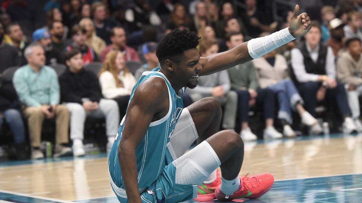 Dec 16, 2024; Charlotte, North Carolina, USA;  Charlotte Hornets forward Brandon Miller (24) signals for someone to help him up after a fall during the second half against the Philadelphia 76ers at the Spectrum Center. Mandatory Credit: Sam Sharpe-Imagn Images