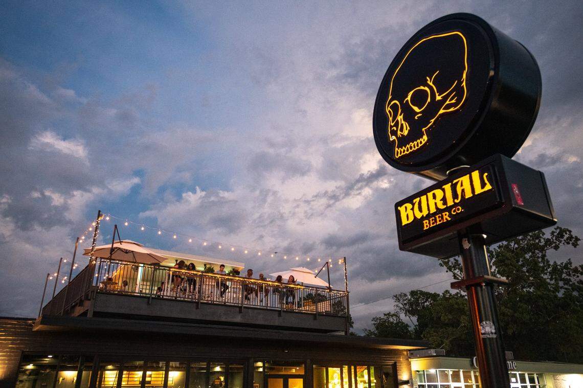 Patrons enjoy drinks on the rooftop bar at Burial Beer Co. in Plaza Midwood.