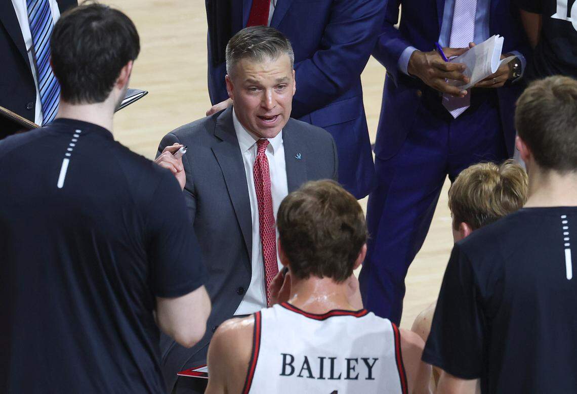 Davidson Wildcats head basketball coach Matt McKillop, center, speaks to his team during a game last season.