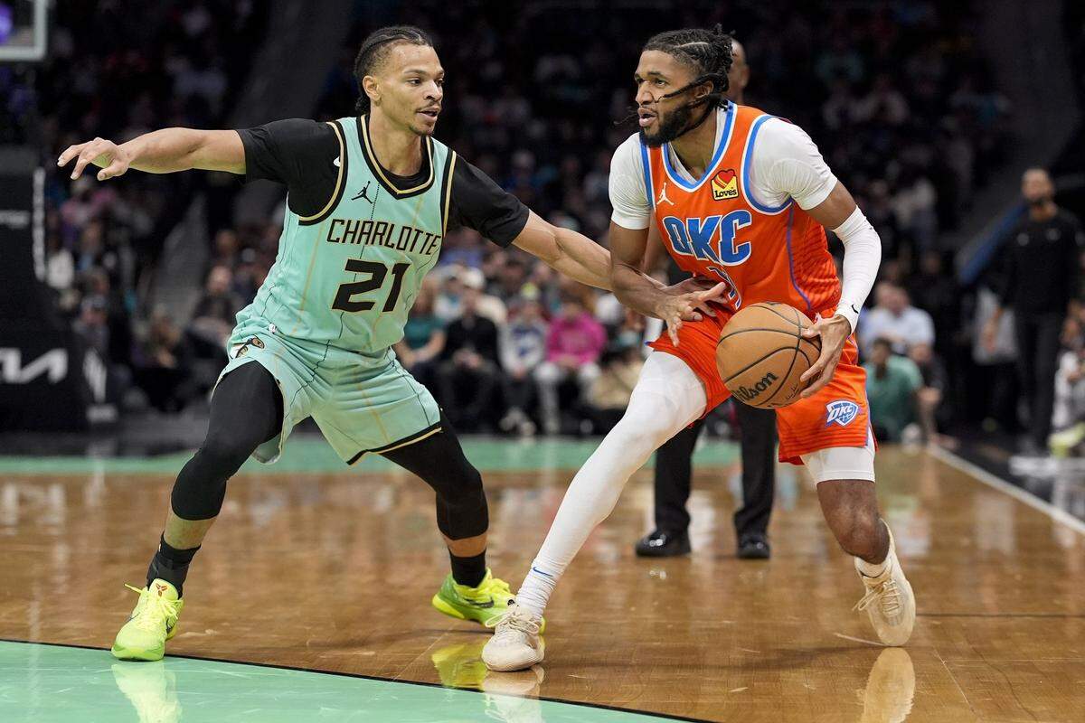 Oklahoma City Thunder guard Isaiah Joe (11) looks to pass defended by Charlotte Hornets guard Isaiah Wong (21) during the second half at Spectrum Center.