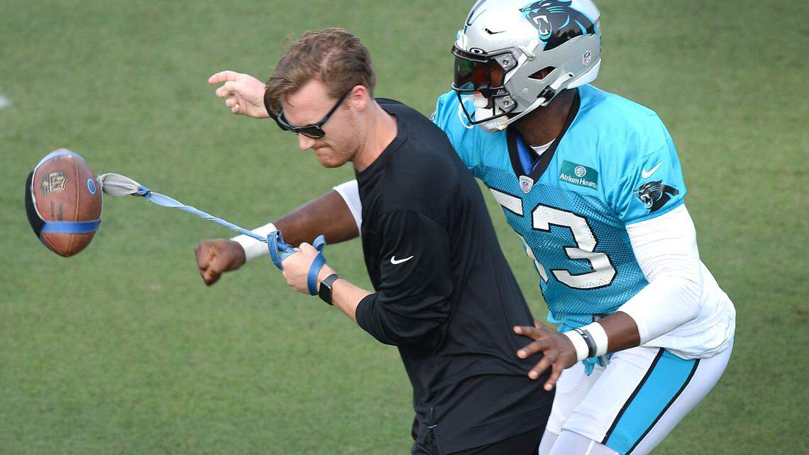 Carolina Panthers assistant equipment manager Danny OÕToole, left, has the ball knocked away by defensive end Brian Burns, right, during practice at Gibbs Stadium on Saturday, July 31, 2021. The team held their practice at Gibbs Stadium as part of the NFLÕs Training Camp: Back Together Saturday celebrating the return of fans and football.