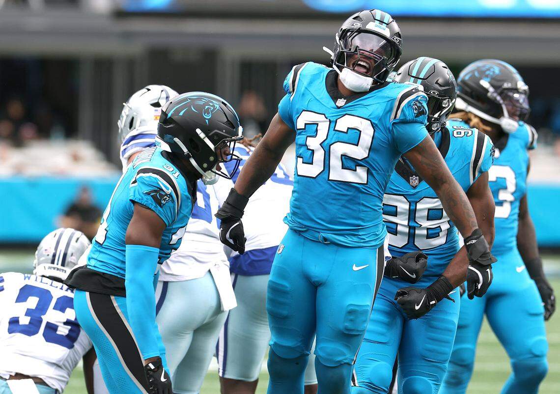 Carolina Panthers linebacker Trevin Wallace, center, celebrates his tackle of Dallas Cowboys running back Javonte Williams during action on Oct. 12, 2025, at Bank of America Stadium. The Panthers defeated the Cowboys 30-27.