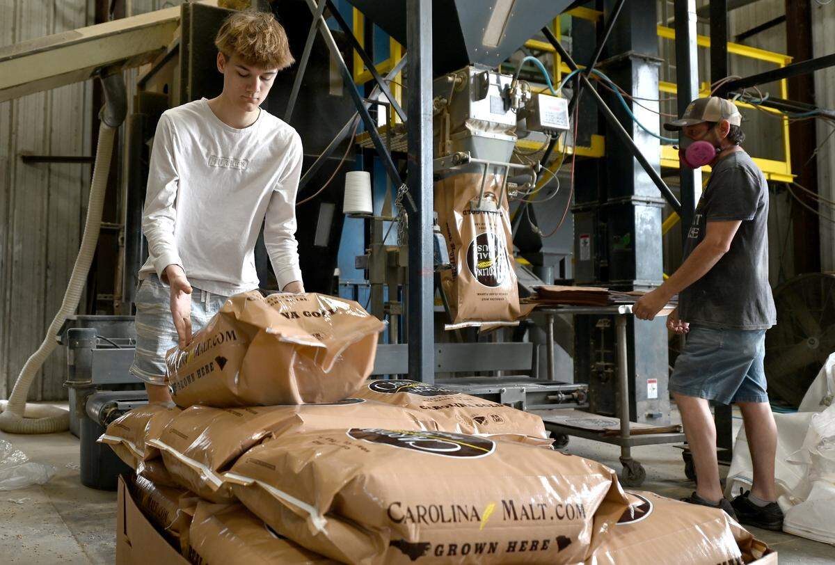 Carolina Malt House employees Eli Barfield and Chad Giles, right, work to fill a customer’s order on Tuesday, April 23, 2025.