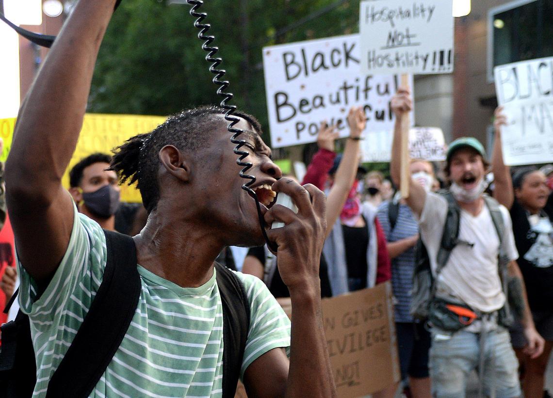 Demonstrators follow the instructions of the leader of a march in uptown Charlotte, NC on S. Tryon St. on Friday, June 5, 2020. Demonstrators have been marching throughout Charlotte for eight days in response to the killing of George Floyd, a black man who was killed on Monday, May 25, 2020 by a Minneapolis, MN police officer.