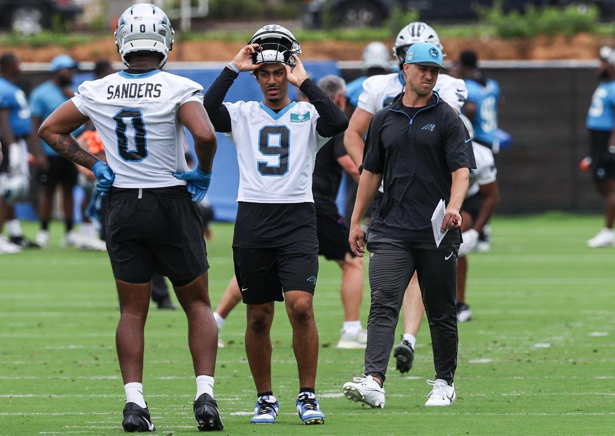 Panthers quarterback Bryce Young, center, takes off his helmet between drills during the first day of minicamp in Charlotte, NC on Tuesday, June 10, 2025.
