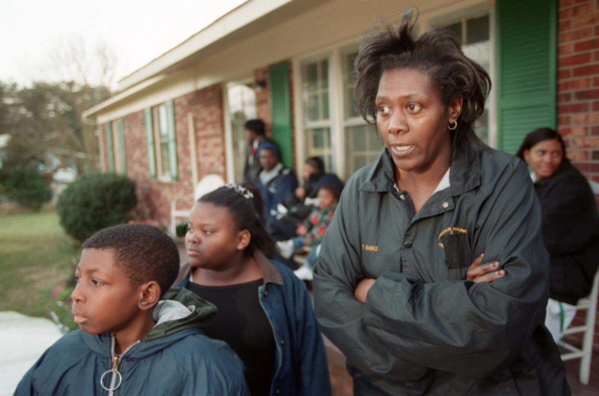 Relatives of Asha Degree, 9, who has been missing from her Cleveland County home since Feb. 14, 2000, watch and wait for word about the little girl across the street from her home. From left to right are Asha’s cousins, Thomas Banks, 12, and Summer Degree, 11, and aunt Patricia Banks (Thomas’ mother).