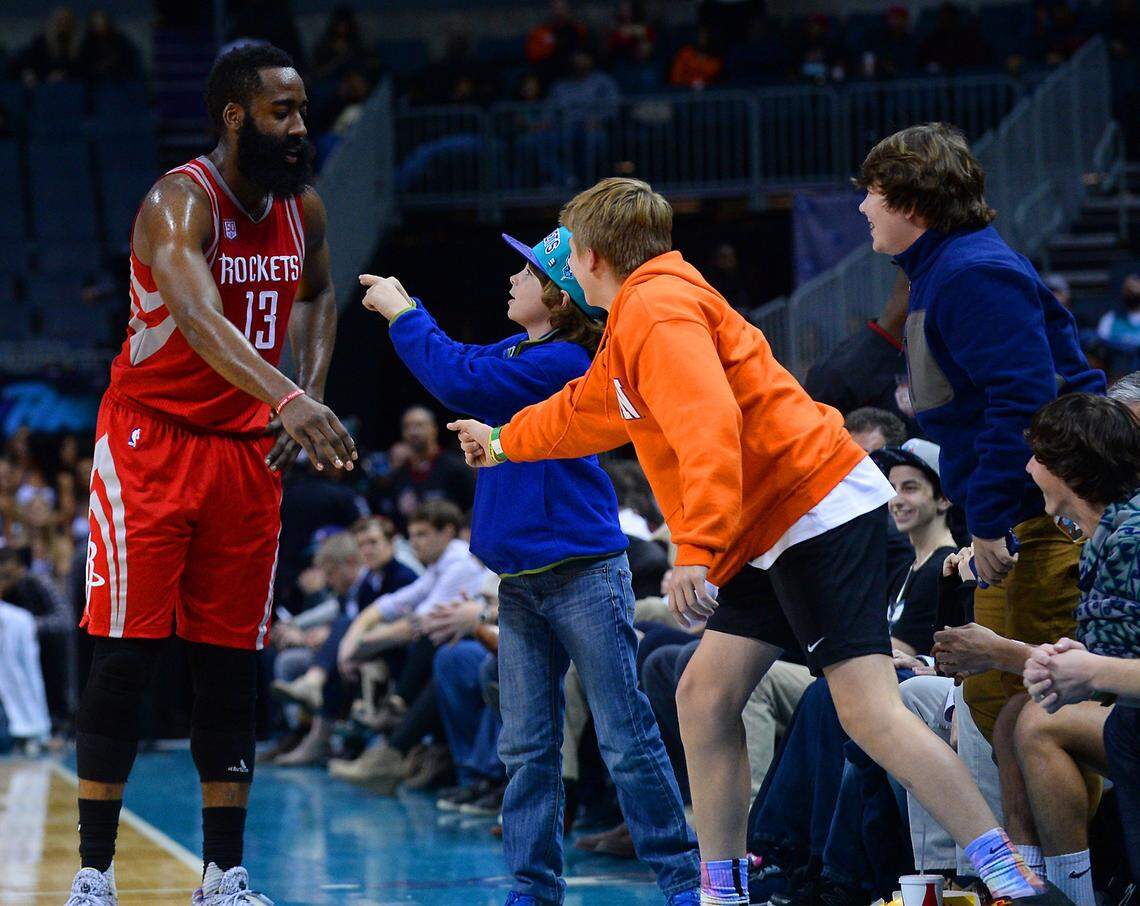 Houston Rockets guard James Harden, left, stops to talk with young fans along courtside during late second half action against the Charlotte Hornets at the Spectrum Center in Charlotte, NC on Thursday, February 9, 2017. The Rockets defeated the Hornets 107-95.