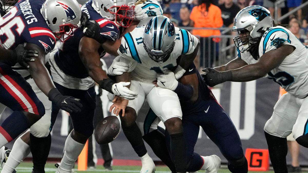 Carolina Panthers quarterback PJ Walker (11) fumbles as he is sacked by New England Patriots defensive end DaMarcus Mitchell, behind, in the end zone during the second half of a preseason NFL football game Friday, Aug. 19, 2022, in Foxborough, Mass. Patriots defensive tackle Sam Roberts (96) recovered the ball for a touchdown in New England’s 20-10 victory.