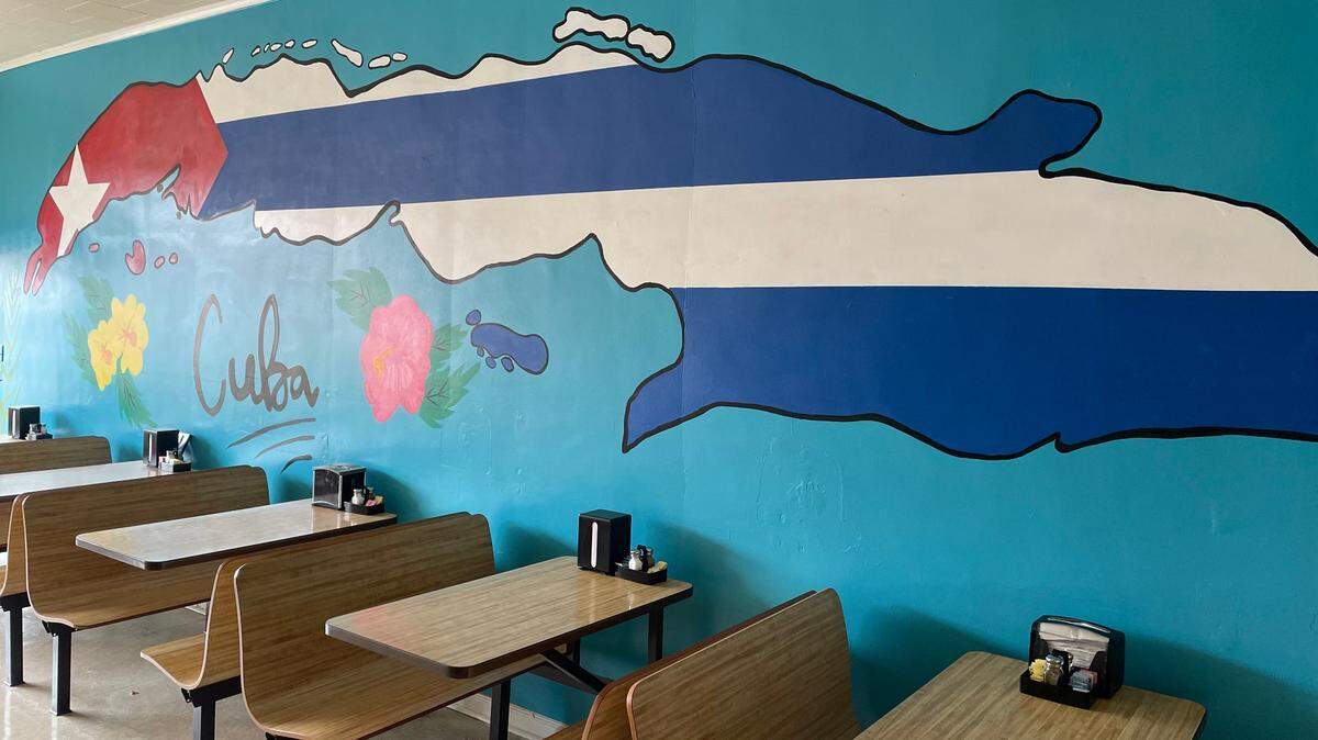 A mural of Cuba by artist Jon Brunelle brightens up the dining room at My Cuban Corner.