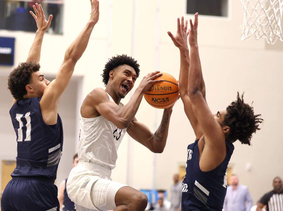 Queens University of Charlotte forward Leo Colimerio, center, drives between two North Florida Ospreys’ defenders to the basket during action on Thursday, January 23, 2025 at Curry Arena in Charlotte, NC. The Ospreys defeated Queens University 90-81.